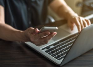 Person using apps on phone and computer